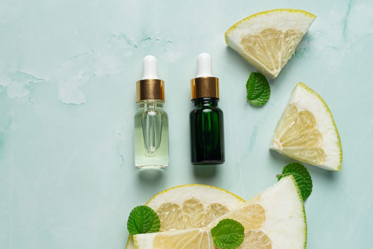 grapefruit oil serum bottle put on green light background
